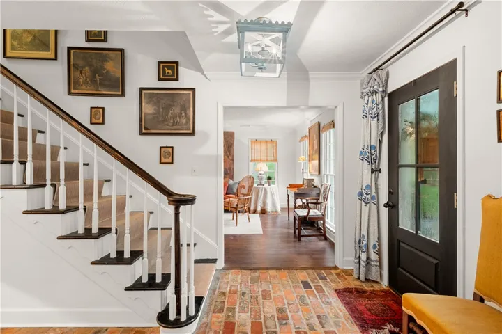 This inviting entryway showcases a beautiful staircase and classic flooring, leading into bright living spaces.