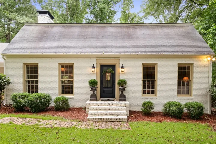 This classic brick residence features a welcoming entrance framed by lush greenery.