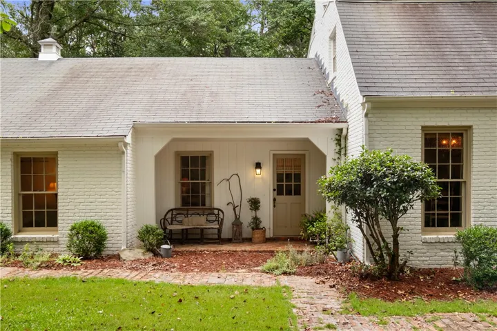This charming residence features classic brick construction and an inviting covered porch.