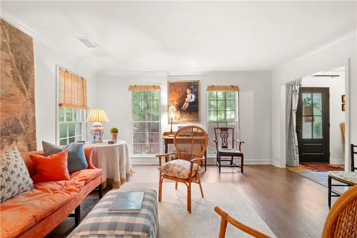 This bright living space features hardwood floors, large windows, and a classic front door.