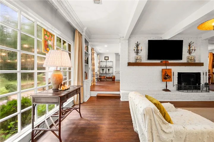 This inviting living space features expansive windows and a cozy fireplace, perfect for relaxation.