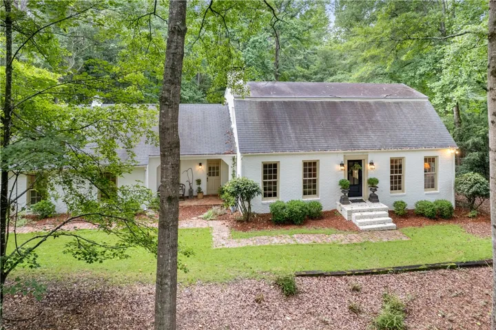 This charming residence is nestled among mature trees, offering a tranquil retreat with classic architectural details.