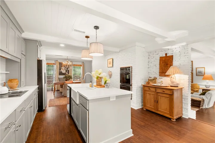 This bright kitchen features a functional island and hardwood floors.