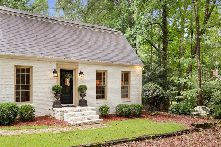 This charming home offers a serene escape, nestled among lush greenery and mature trees.