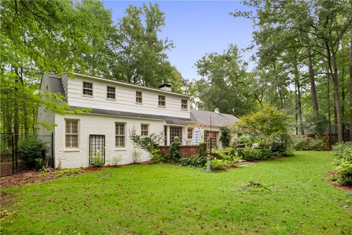 This tranquil backyard offers a peaceful retreat with lush greenery and a charming brick patio.