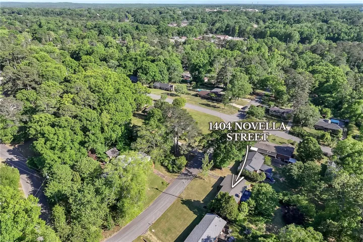 An aerial view showcases a vibrant, tree-lined neighborhood with well-maintained streets and homes.
