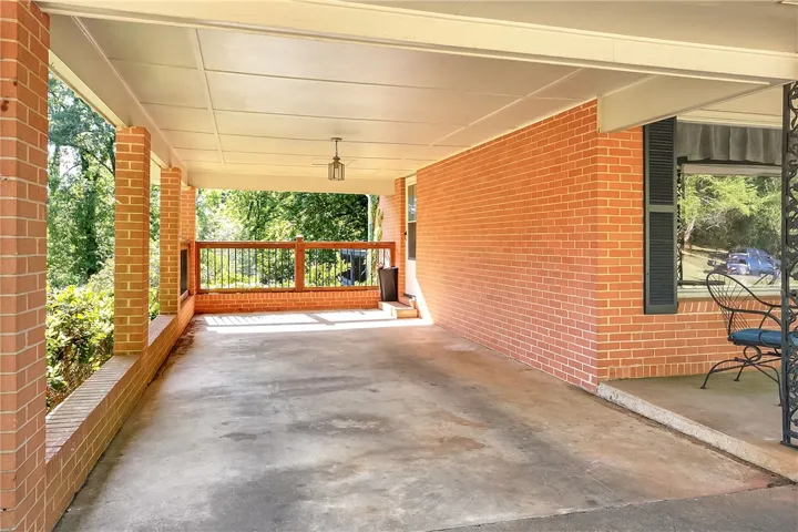 This inviting exterior showcases a charming brick construction with a spacious, covered carport.