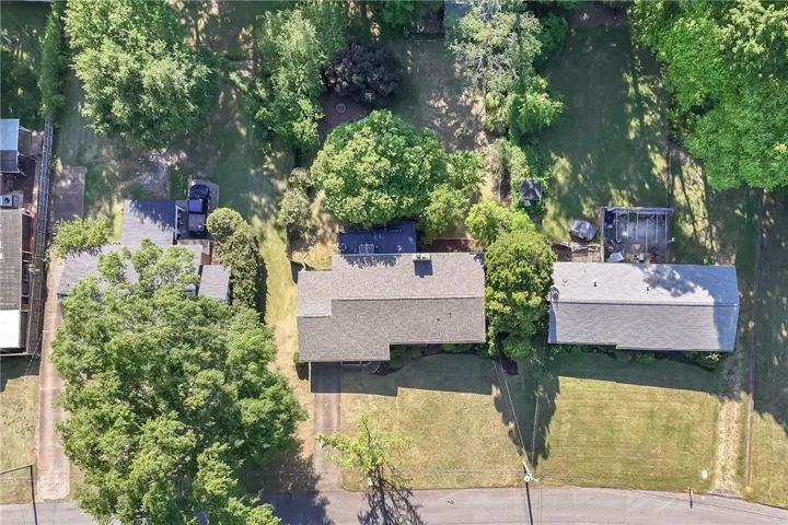 An overhead view reveals a well-maintained property nestled among mature trees and lush green lawns.