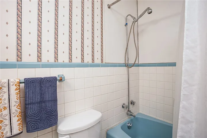 This bathroom offers tiled walls and a combination shower-bathtub for everyday convenience.
