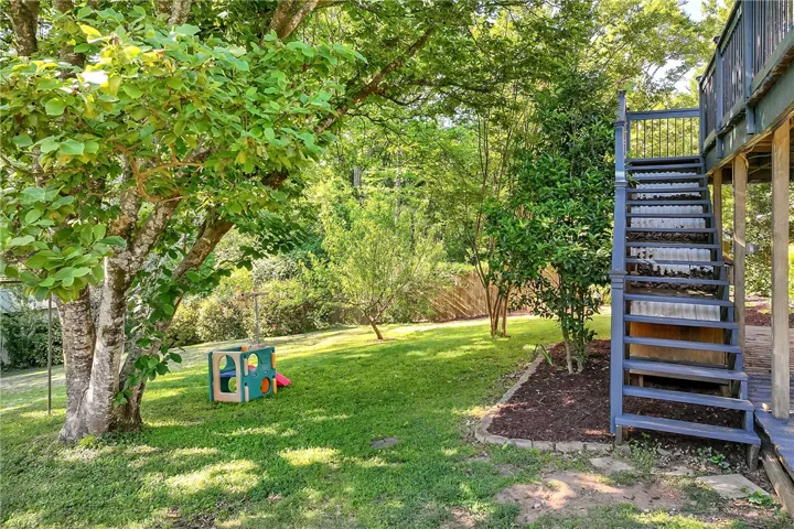 This spacious yard offers a vibrant green lawn and mature trees, perfect for outdoor enjoyment.