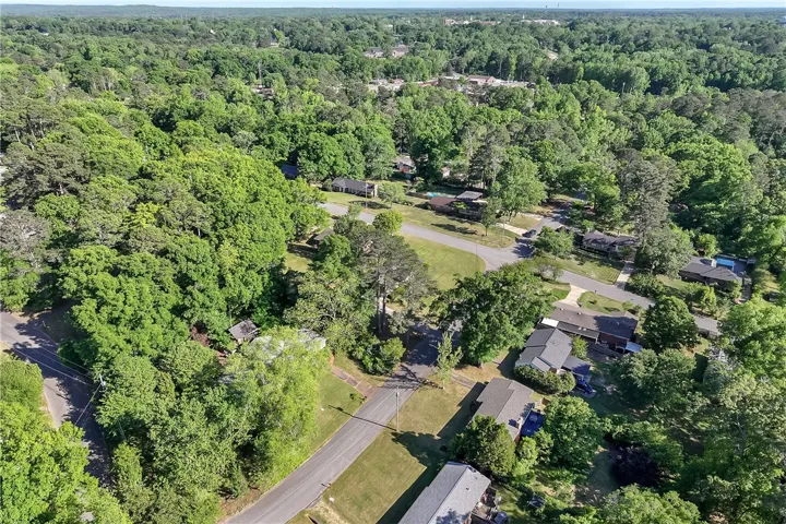 This elevated view captures a serene residential landscape nestled among lush, mature trees.