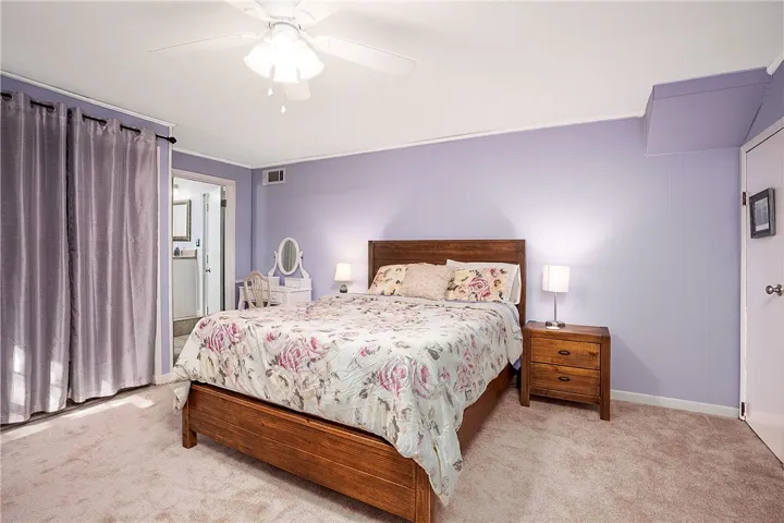 This spacious bedroom offers a tranquil retreat with soft carpet flooring.