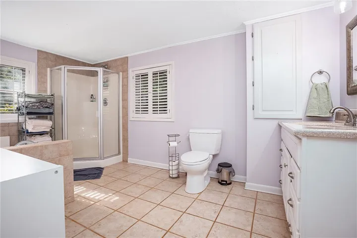 This bright bathroom features a spacious shower and ample counter space, creating a refreshing atmosphere.