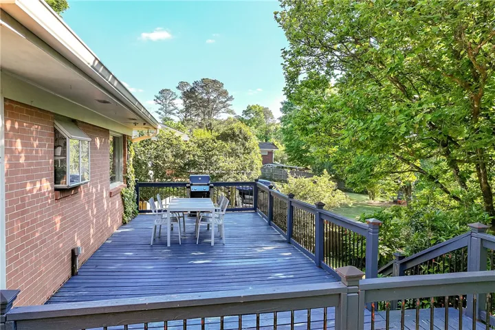 This spacious outdoor deck provides a perfect setting for entertaining guests and enjoying the surrounding greenery.