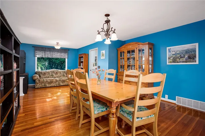 This inviting dining area features warm hardwood floors and ample natural light, perfect for gatherings.