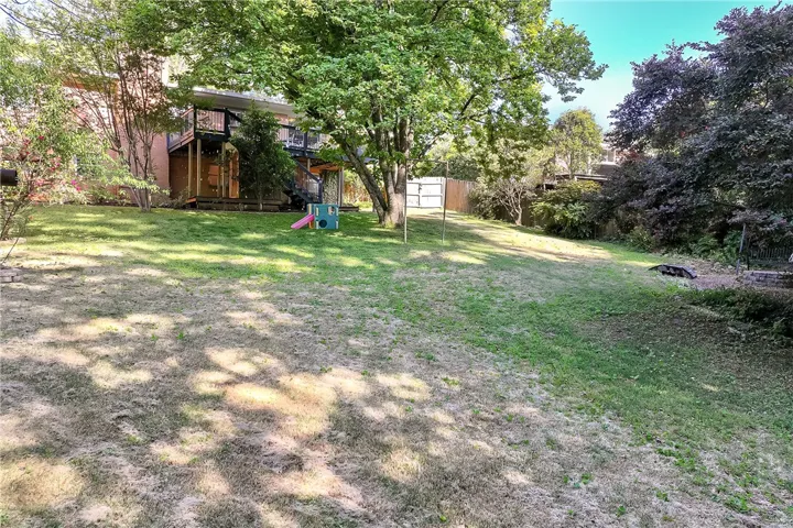 This spacious yard features mature trees and a private setting, perfect for outdoor activities.