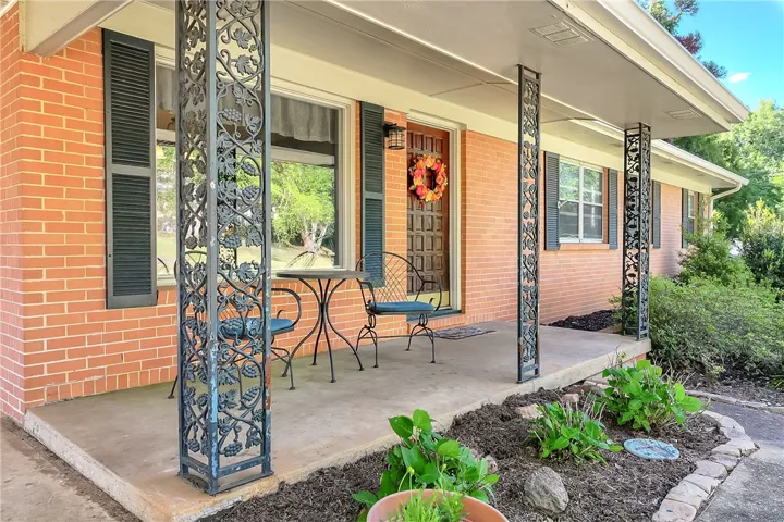 This charming residence features a welcoming front porch with decorative columns and well-maintained landscaping.