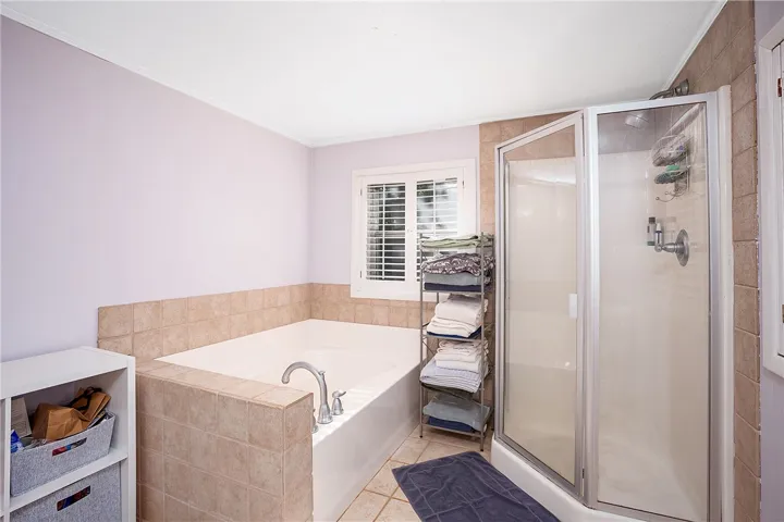 This primary bathroom offers a relaxing soaking tub and a functional shower for daily routines.