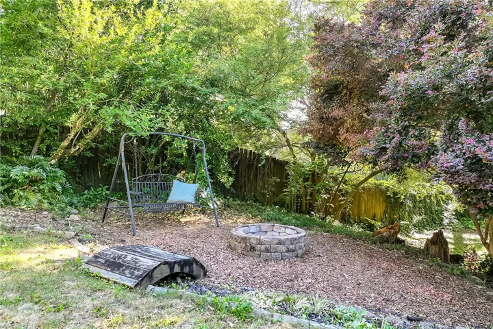 This private yard offers a peaceful retreat with a cozy fire pit and ample green space.