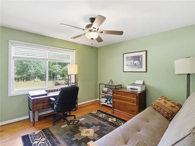 This versatile room offers a tranquil workspace with views of lush greenery.