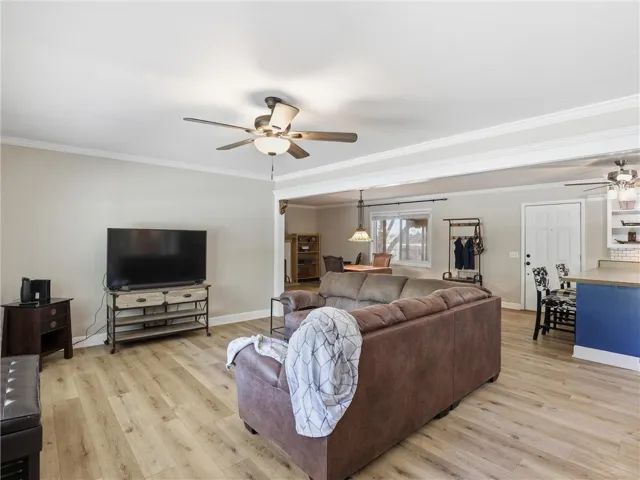 This inviting space features light wood flooring and a refreshing ceiling fan, perfect for relaxed living.