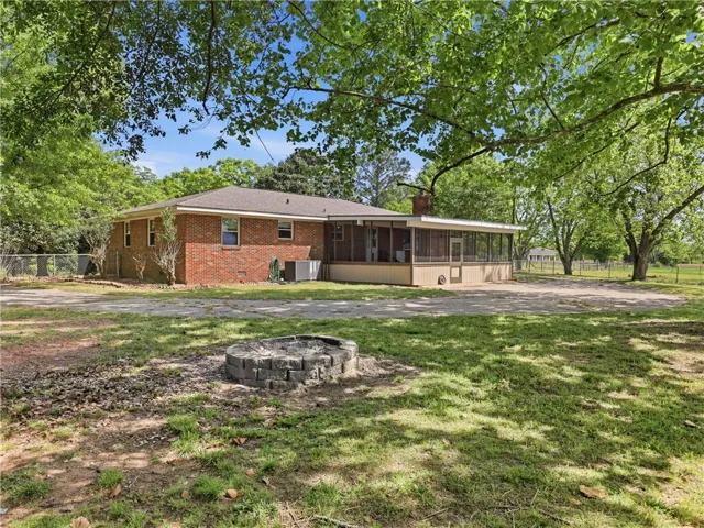 This ranch-style residence features a screened porch and a fire pit, perfect for outdoor enjoyment.