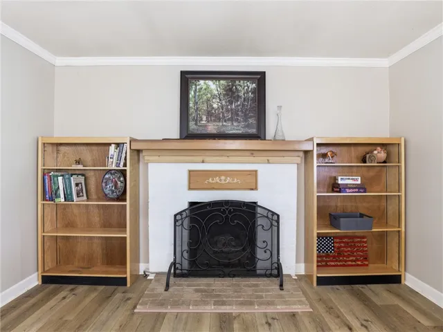 This inviting room showcases a fireplace with an elegant mantel and built-in shelving.