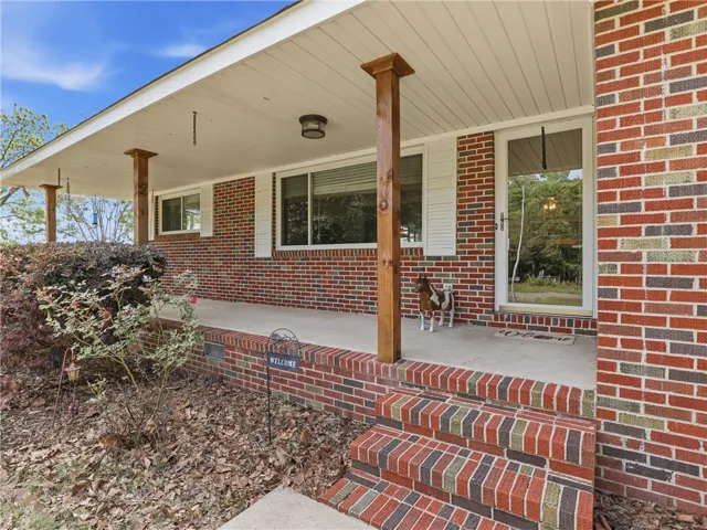 This charming home offers a welcoming brick exterior with a classic covered porch.