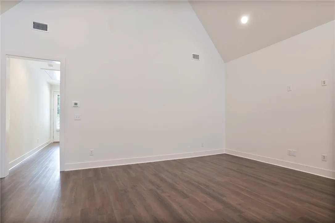 This bright room features vaulted ceilings and rich wood flooring, creating an inviting space.