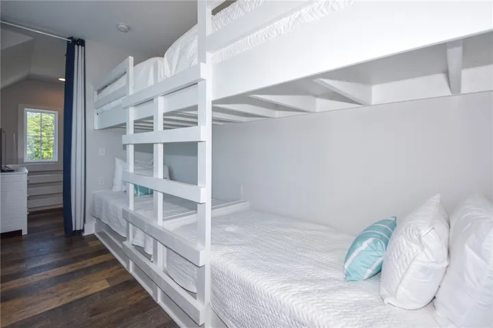 This cozy bedroom features built-in bunk beds and durable flooring.