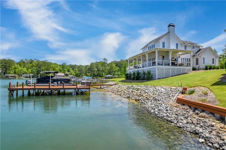 This serene waterfront home boasts a private dock and expansive porch, offering tranquil lake views.