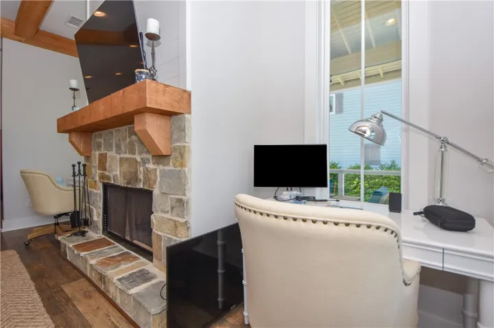 This inviting living space features a cozy fireplace and a dedicated workspace by the window.