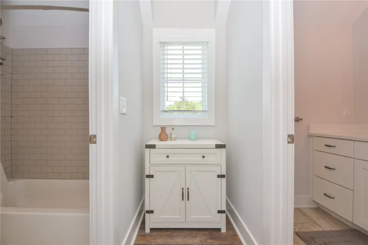 This bathroom features stylish storage, subway tiled shower, and elegant countertops.