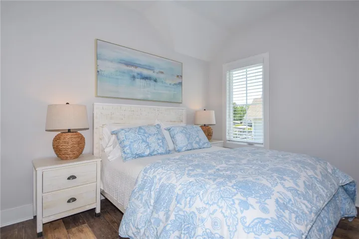 This serene bedroom offers a bright retreat with vaulted ceilings and ample natural light.