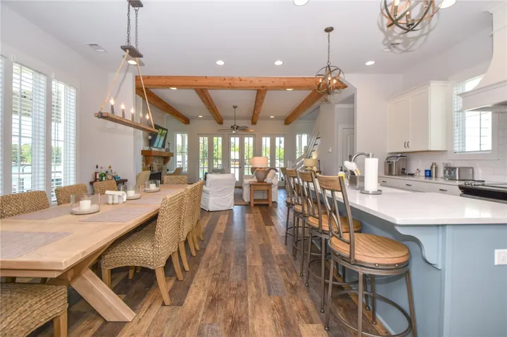 This open concept living area features exposed beam ceilings, sleek flooring, and a modern kitchen.