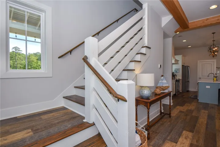 This interior features a wooden staircase leading to upper levels, showcasing durable hardwood flooring.