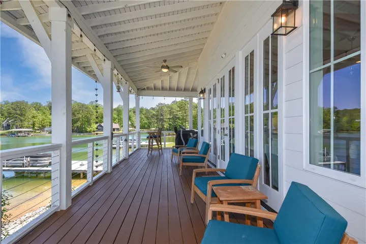 This expansive porch overlooks a serene lake, offering an idyllic setting for outdoor living.
