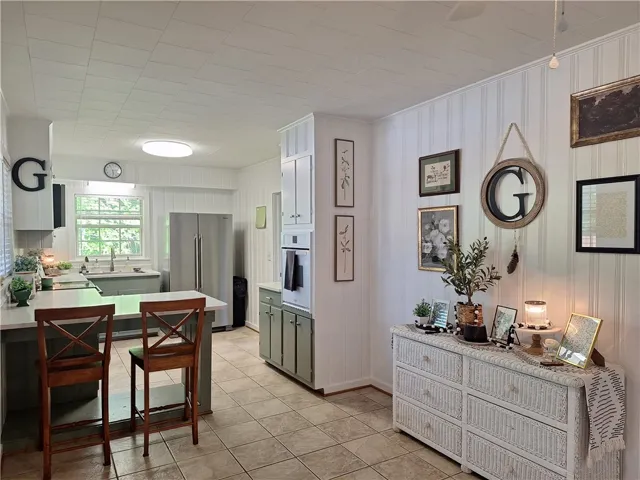 This spacious kitchen offers a large island with seating, ample cabinetry, and sleek stainless steel appliances.
