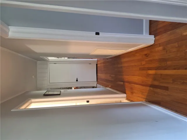This interior hallway features classic wood flooring and crown molding, enhancing its architectural appeal.