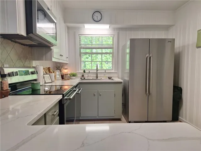 This bright kitchen features sleek countertops and modern appliances, perfect for culinary endeavors.