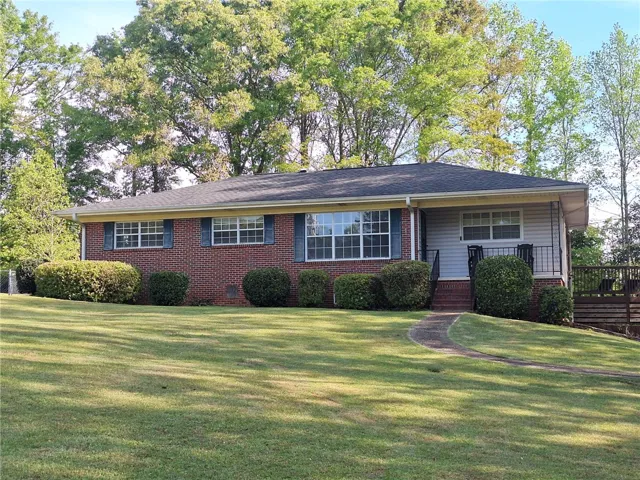 This charming home features a classic brick and siding exterior, nestled on a well-maintained lawn.
