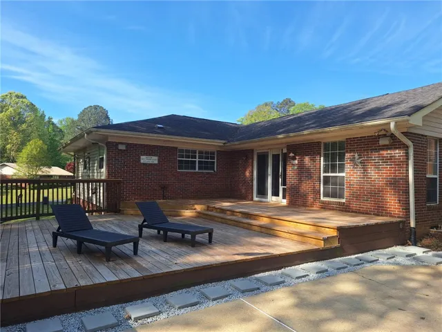 This residence features a spacious wooden deck, perfect for outdoor relaxation and entertaining.