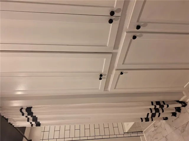 This bathroom features white cabinetry and subway tile, creating a crisp, clean aesthetic.