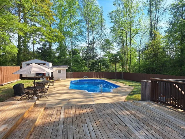This spacious backyard oasis features a beautiful pool and large deck for outdoor enjoyment.