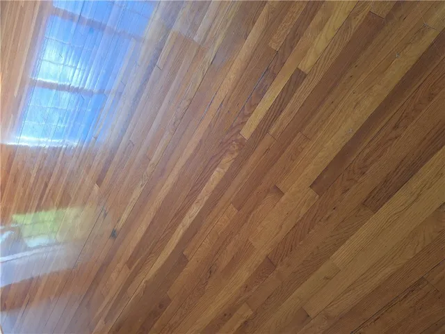 Natural hardwood flooring reflects ample light, enhancing the room's inviting atmosphere.