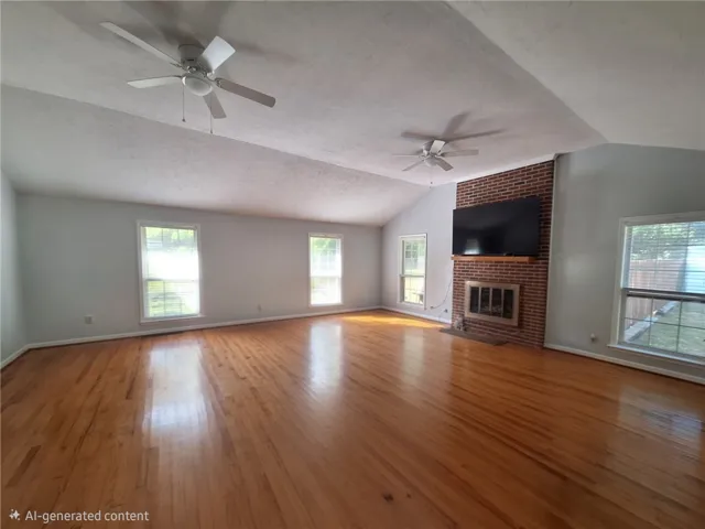This expansive living space features rich hardwood floors and a cozy brick fireplace.