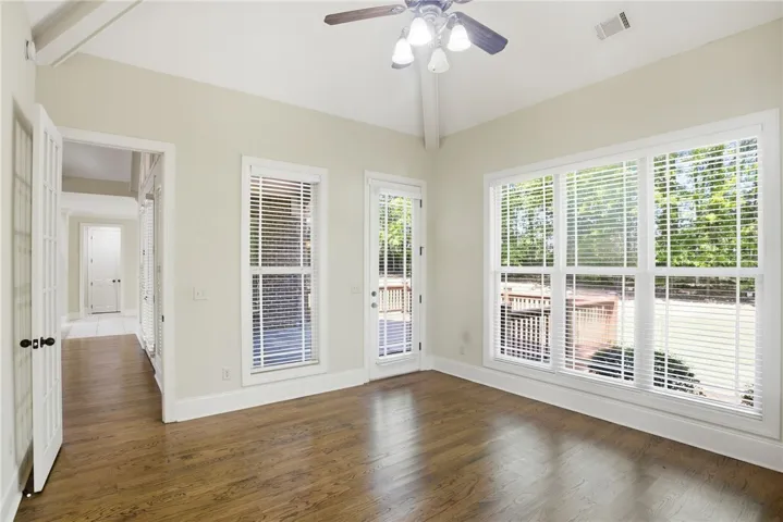 This airy bonus room features rich hardwood flooring and large windows, connecting seamlessly to the outdoors.