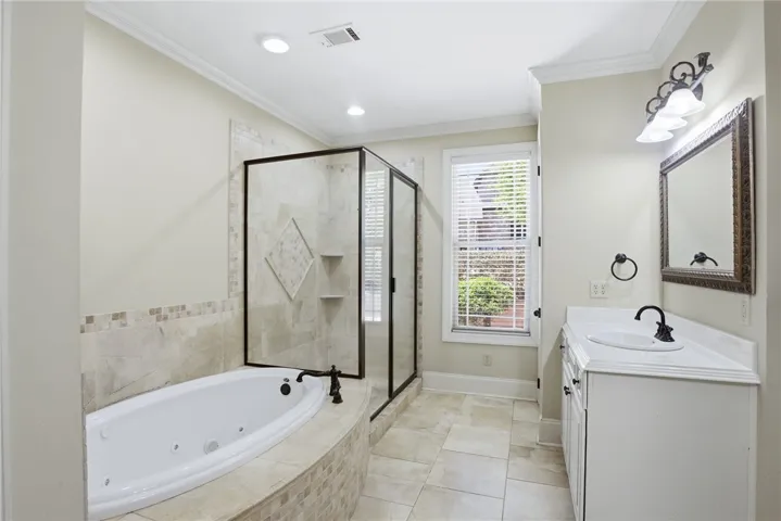 This serene bathroom offers a soaking tub and a spacious shower, creating a relaxing retreat.