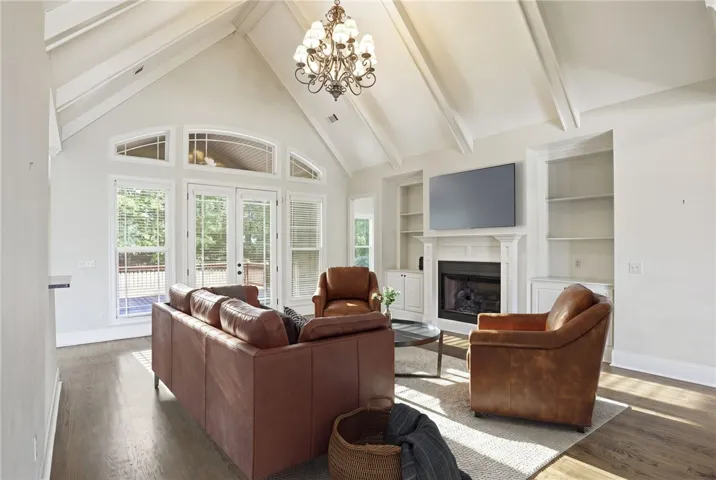 This living room features vaulted ceilings, a fireplace, and hardwood flooring. Virtually Staged.