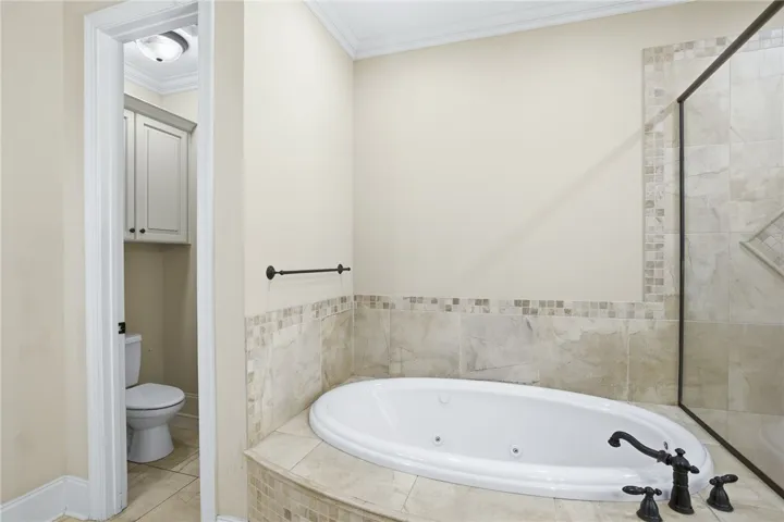 Relax in this inviting bathroom featuring a deep soaking tub and tiled shower.